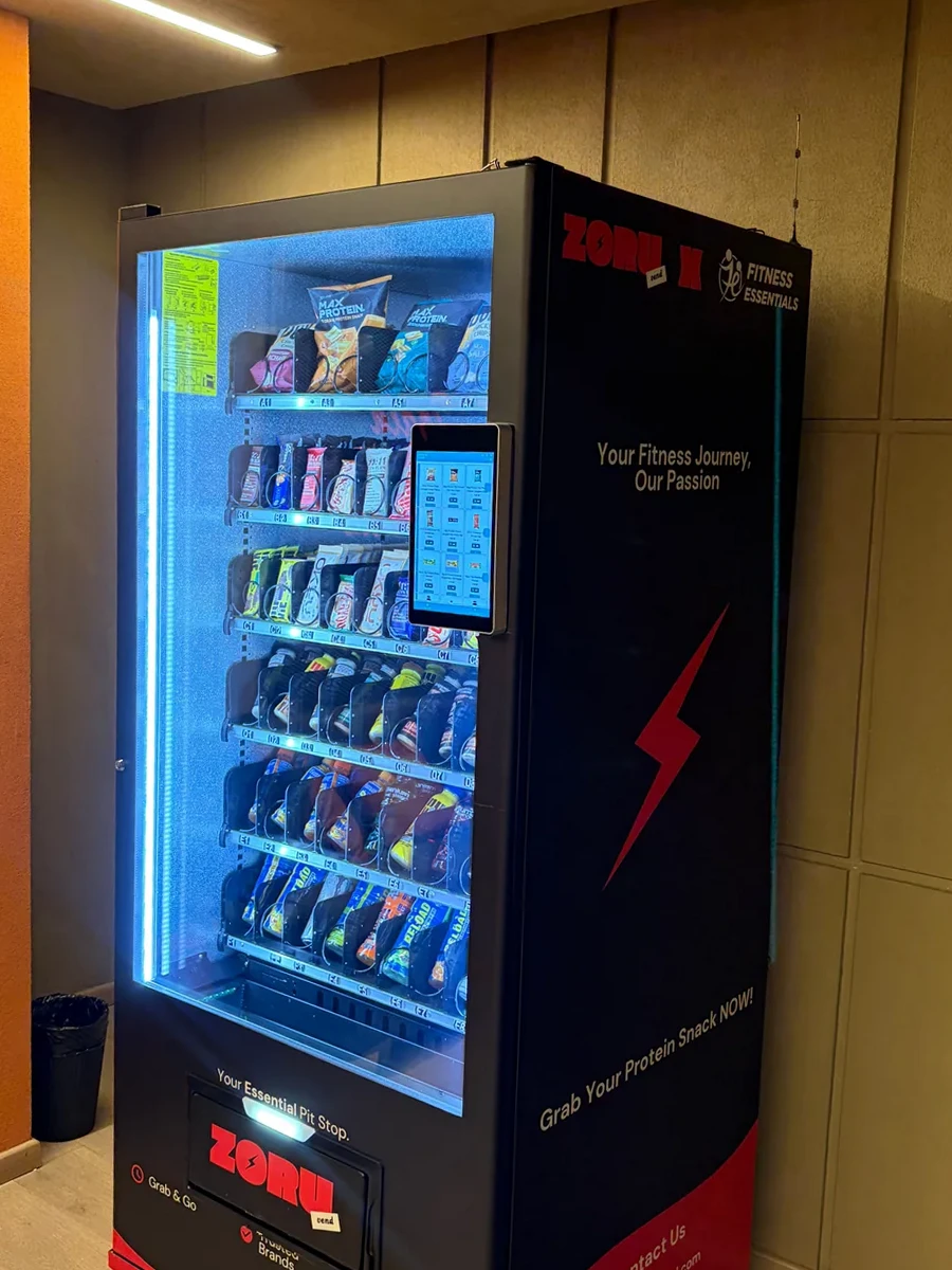 A Zoruvend machine installed against the wall of a fitness facility, its branded side panel reading Your Fitness Journey, Our Passion